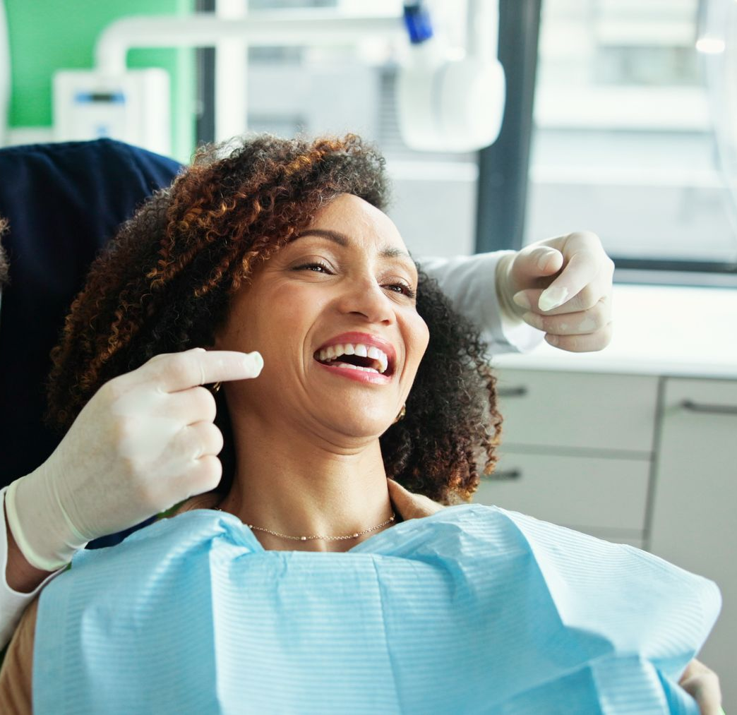 A woman with braces and a ring on her finger is smiling.