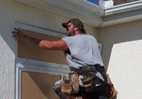 Man with hat working on window — Leesburg, FL — Aluminum Contractors Inc
