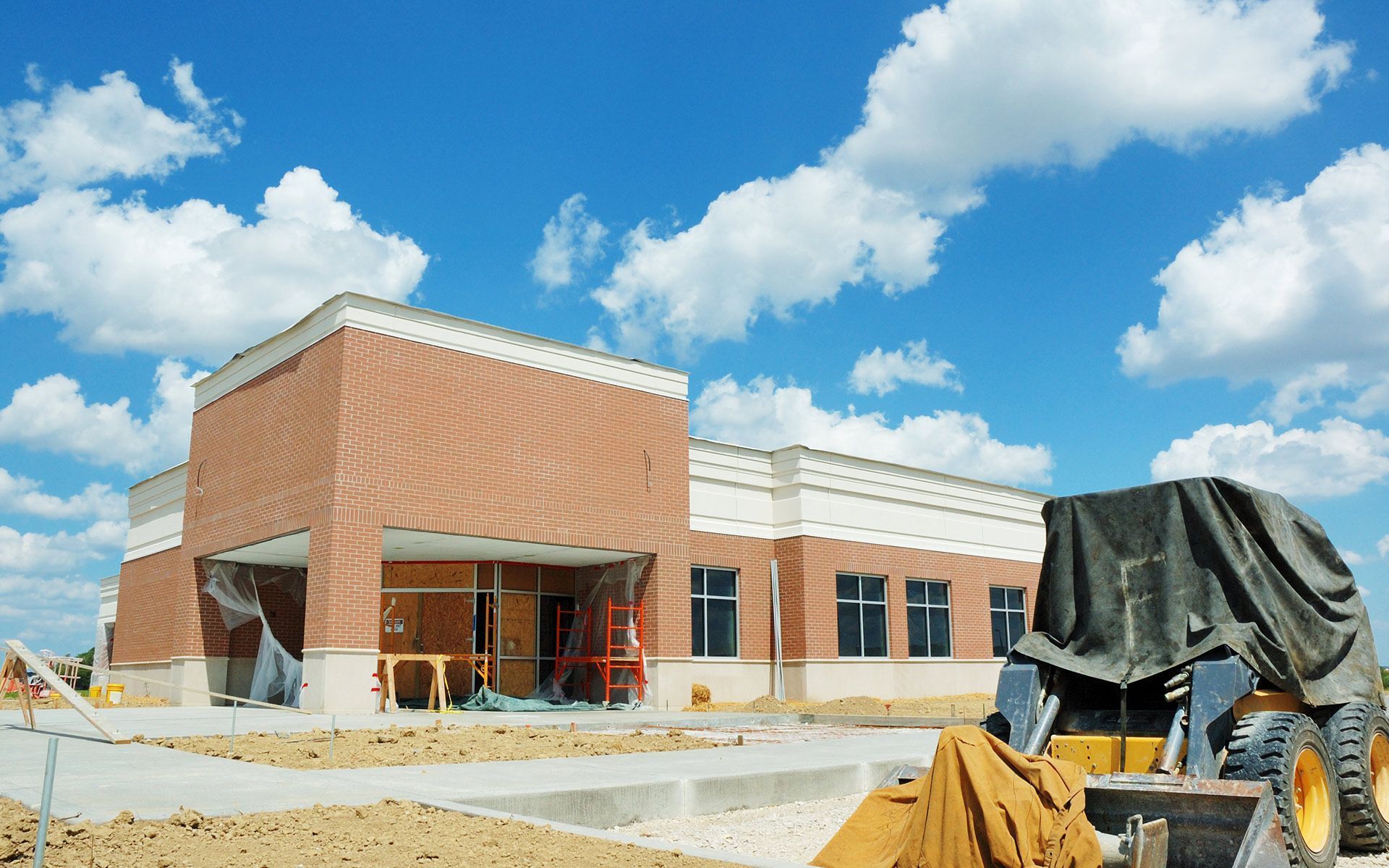 A building under construction with a bulldozer in front of it