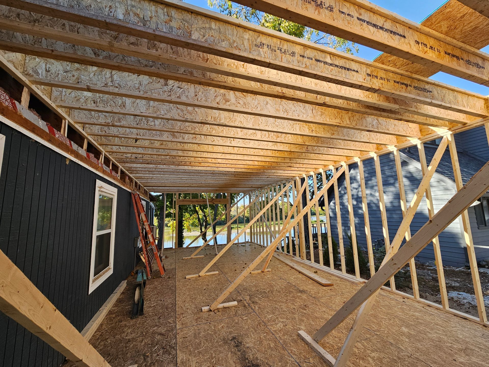 A house is being built with wooden beams and a ladder