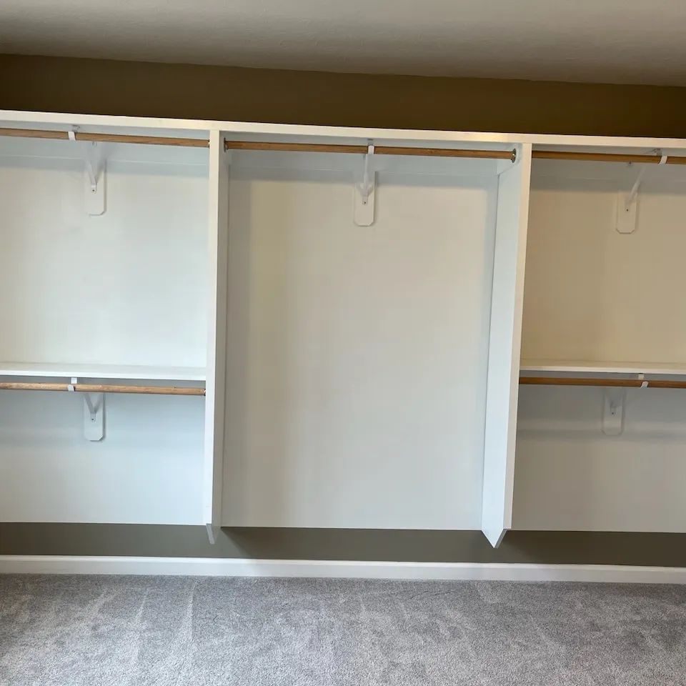 A closet with a lot of shelves and clothes racks .