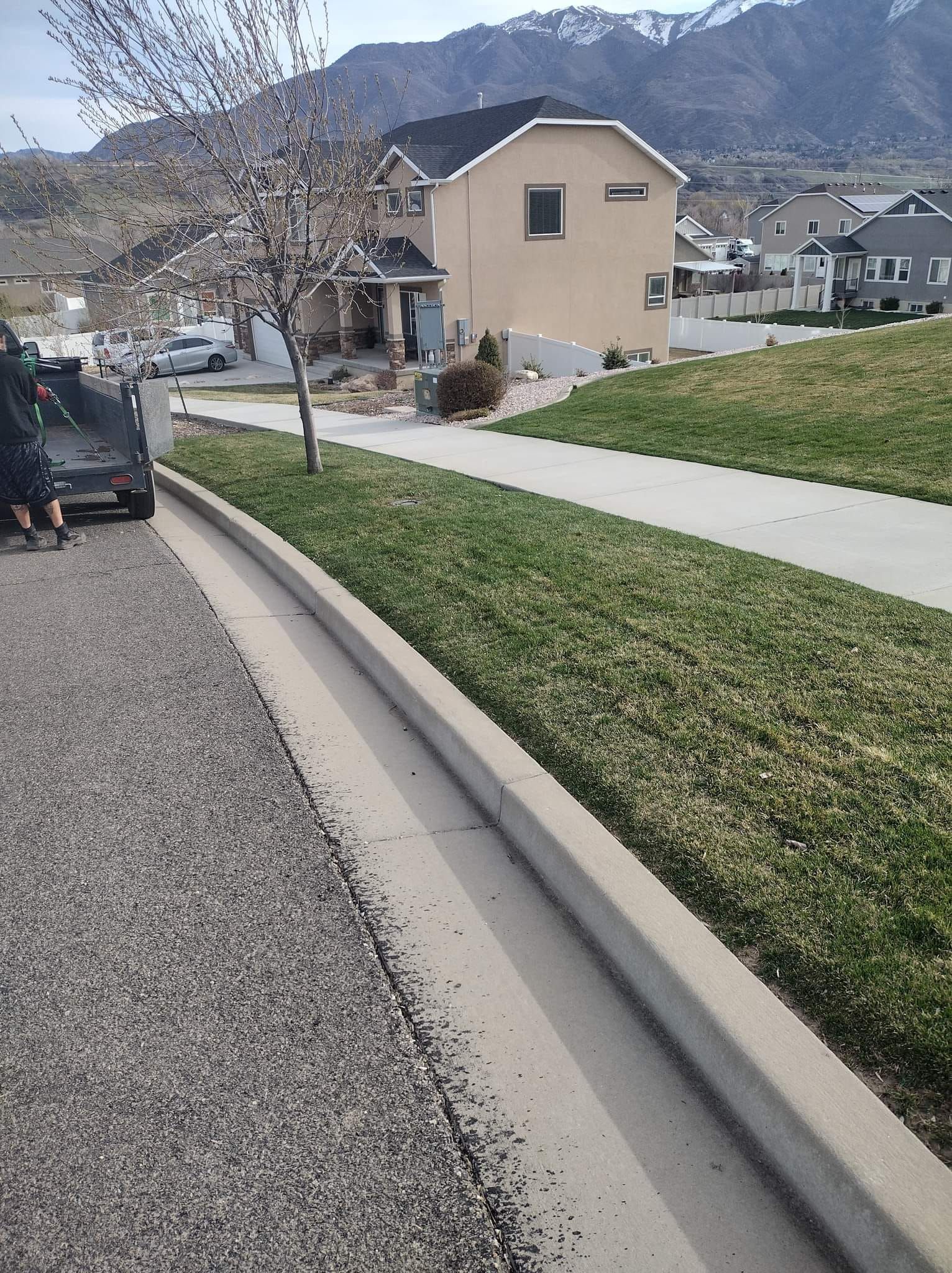 A car is parked on the side of the road in front of a house.