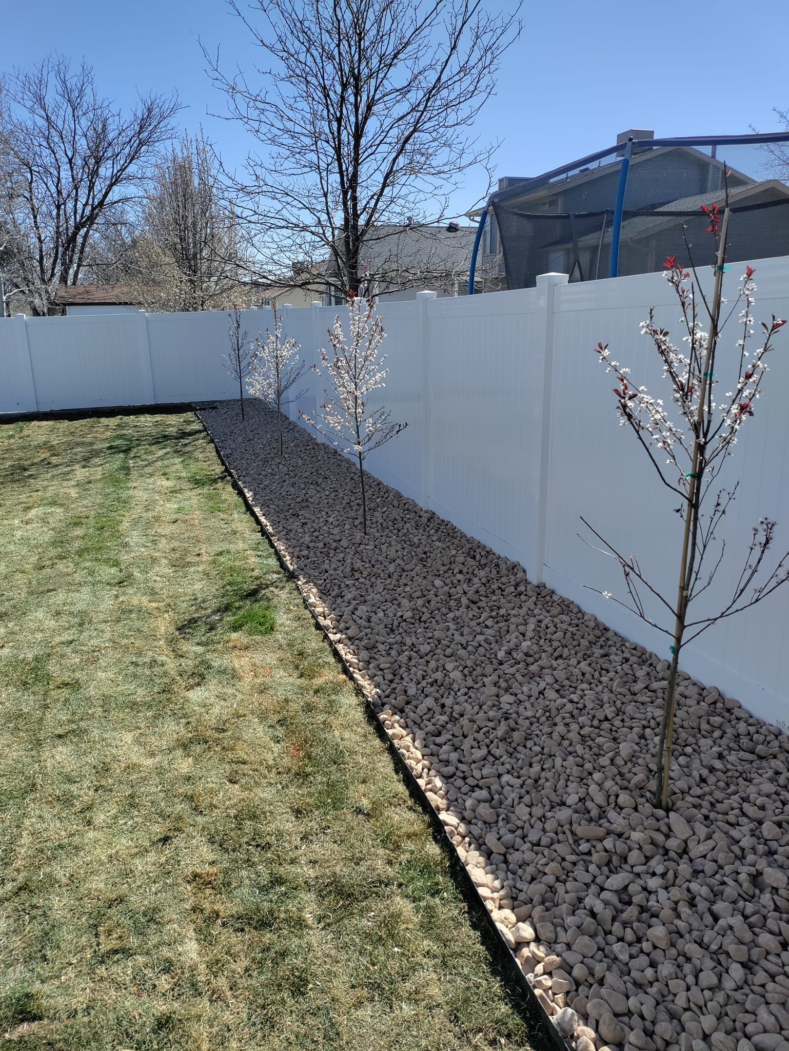 A white fence with a tree in front of it