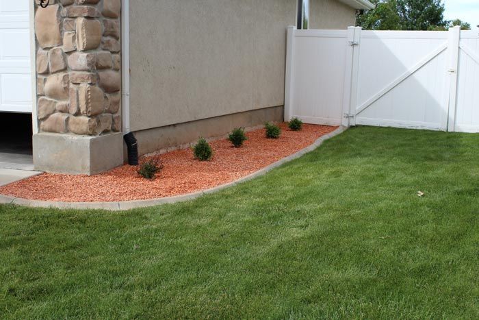 A backyard with a white fence and a white garage door.