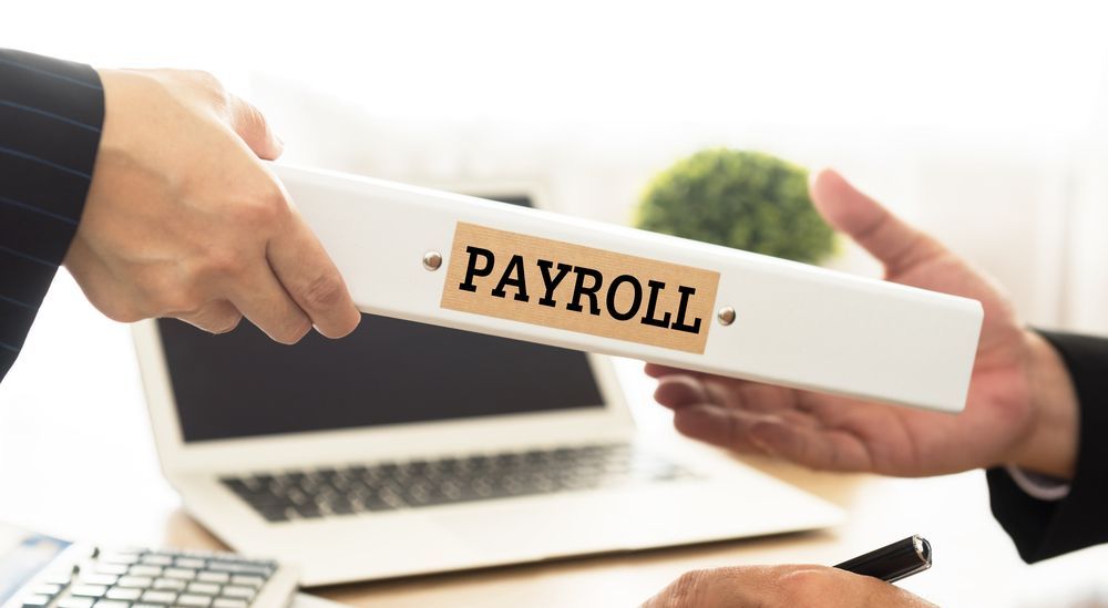 A Person Is Handing Another Person A Payroll Binder — Blue Chip Bookkeeping In Nome, QLD