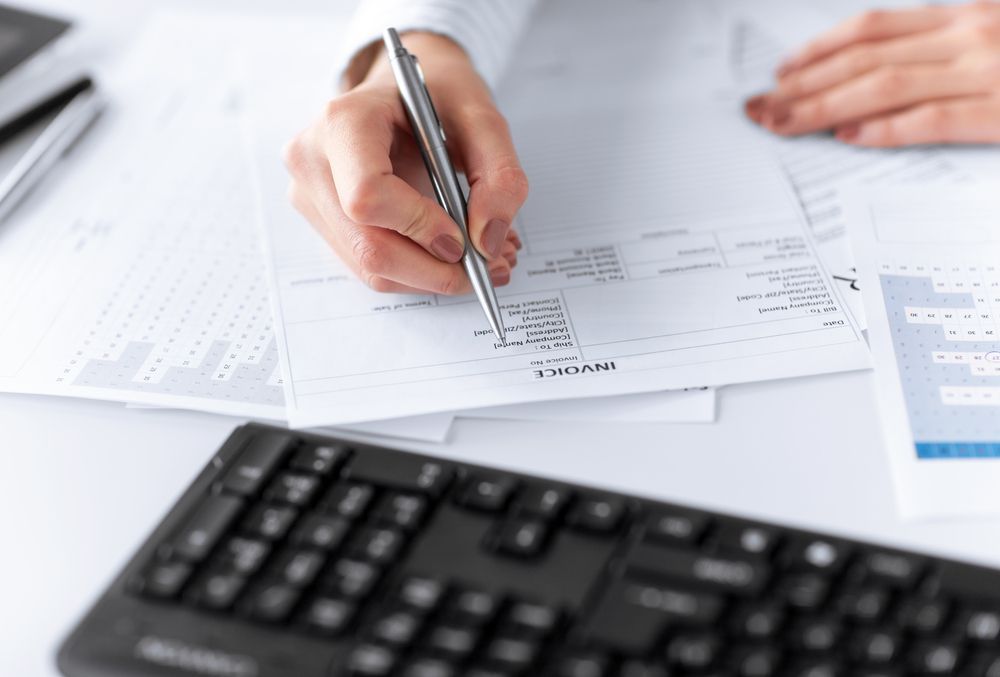 Woman Filling In An Invoice Paper — Blue Chip Bookkeeping In Nome, QLD
