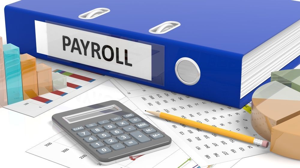 Payroll Word On Blue Binder And A Calculator Placed On Table — Blue Chip Bookkeeping In Nome, QLD