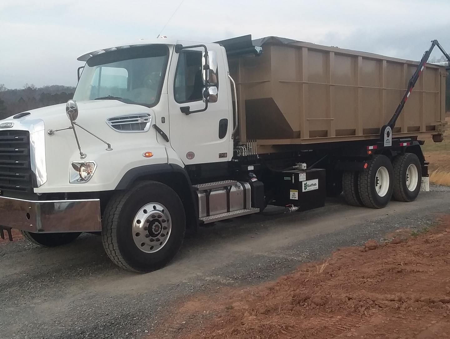 A dump truck is parked on the side of the road.