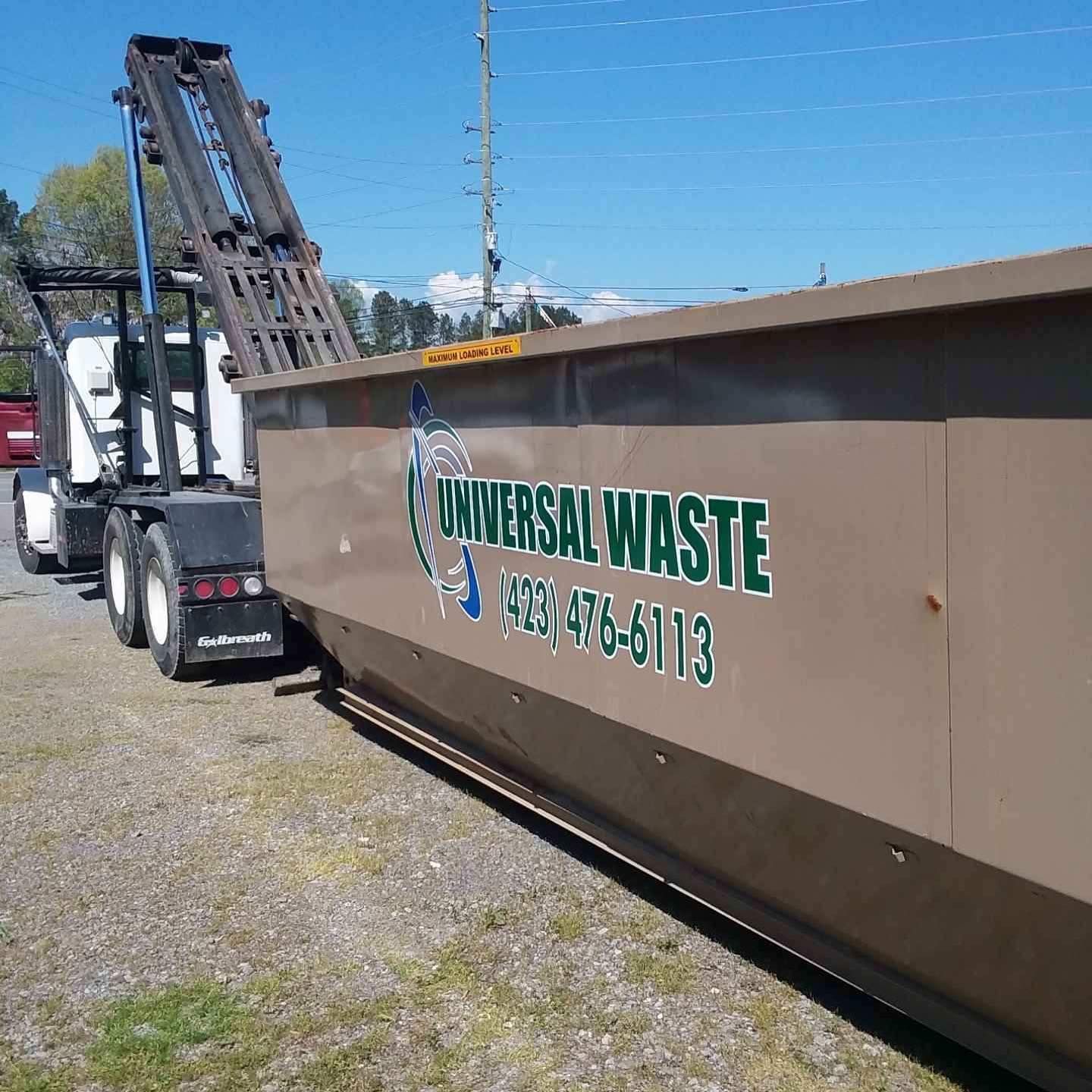 A dumpster with the word universal waste on it