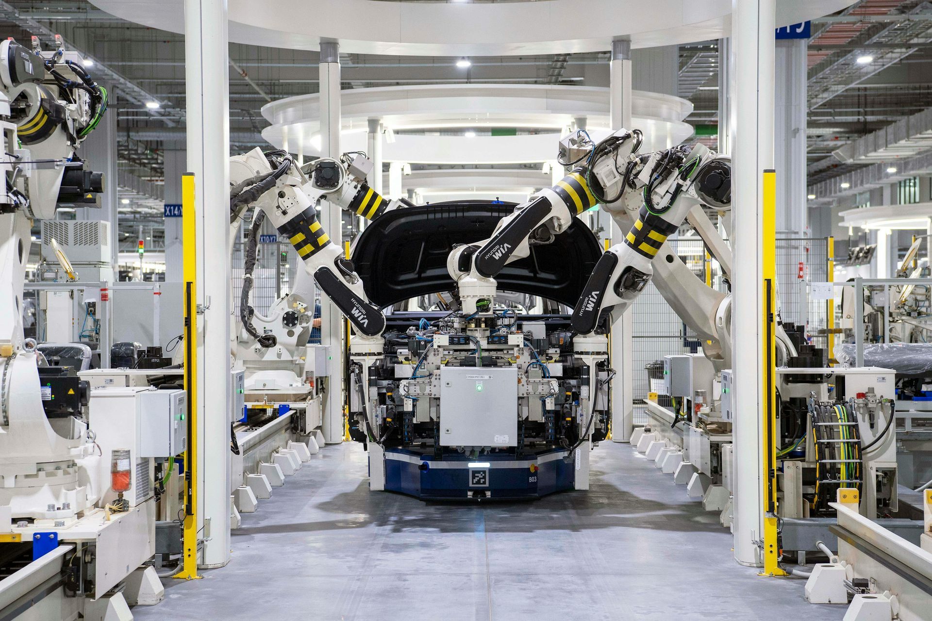 Robotic arms assembling a car body on a factory production line