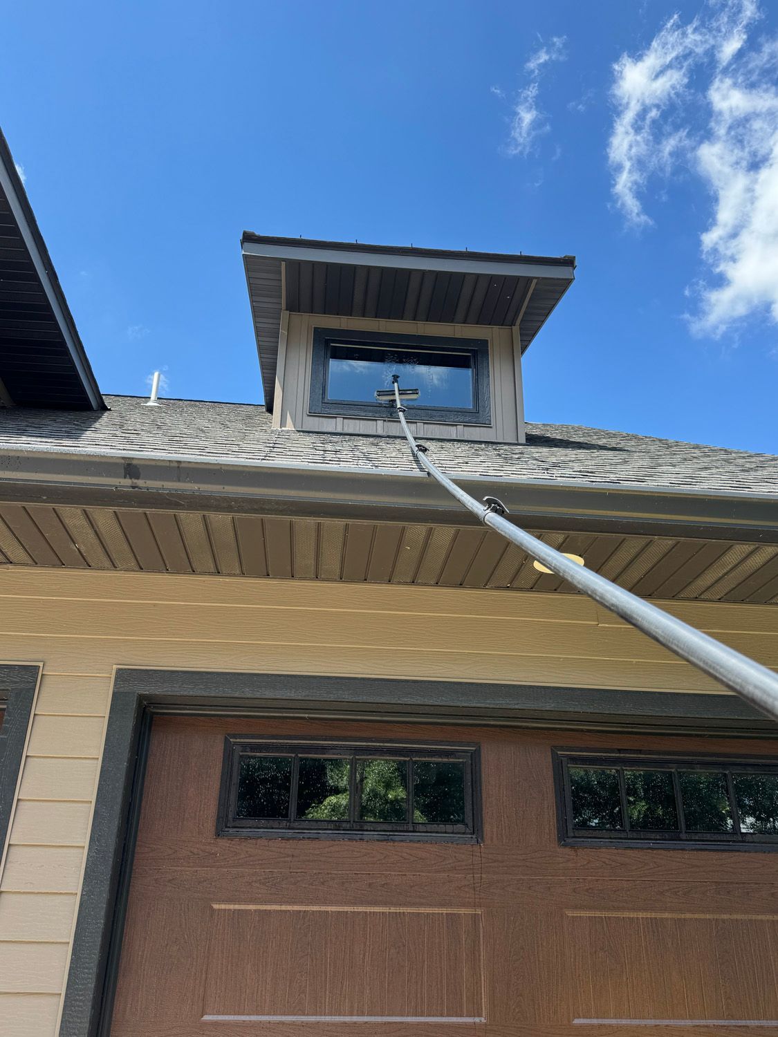 Cable reaching up to a roof vent on a house under a blue sky