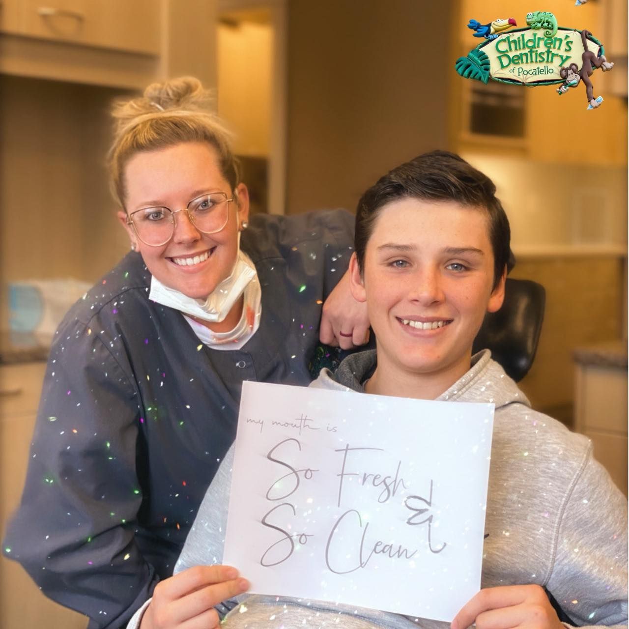 Dentist and patient smiling, holding 
