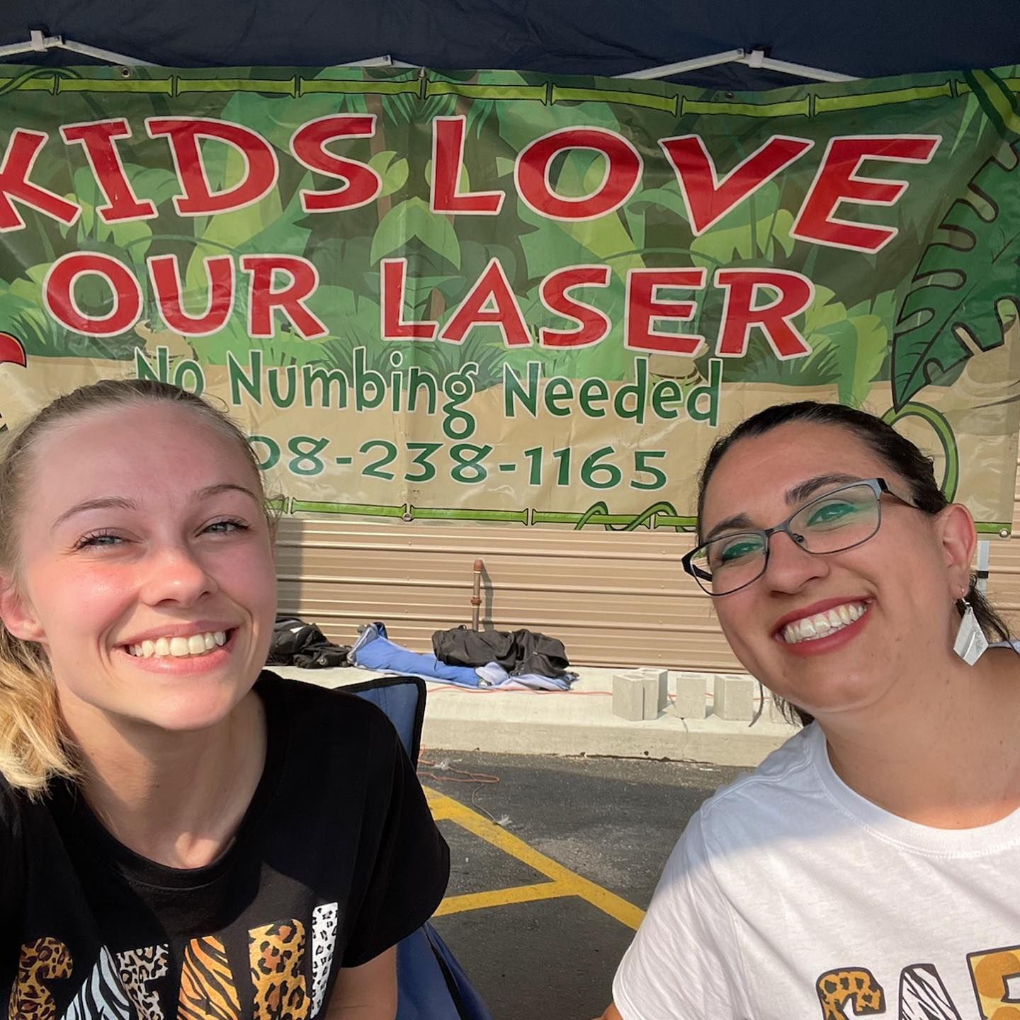 Two smiling people in front of a banner that says 