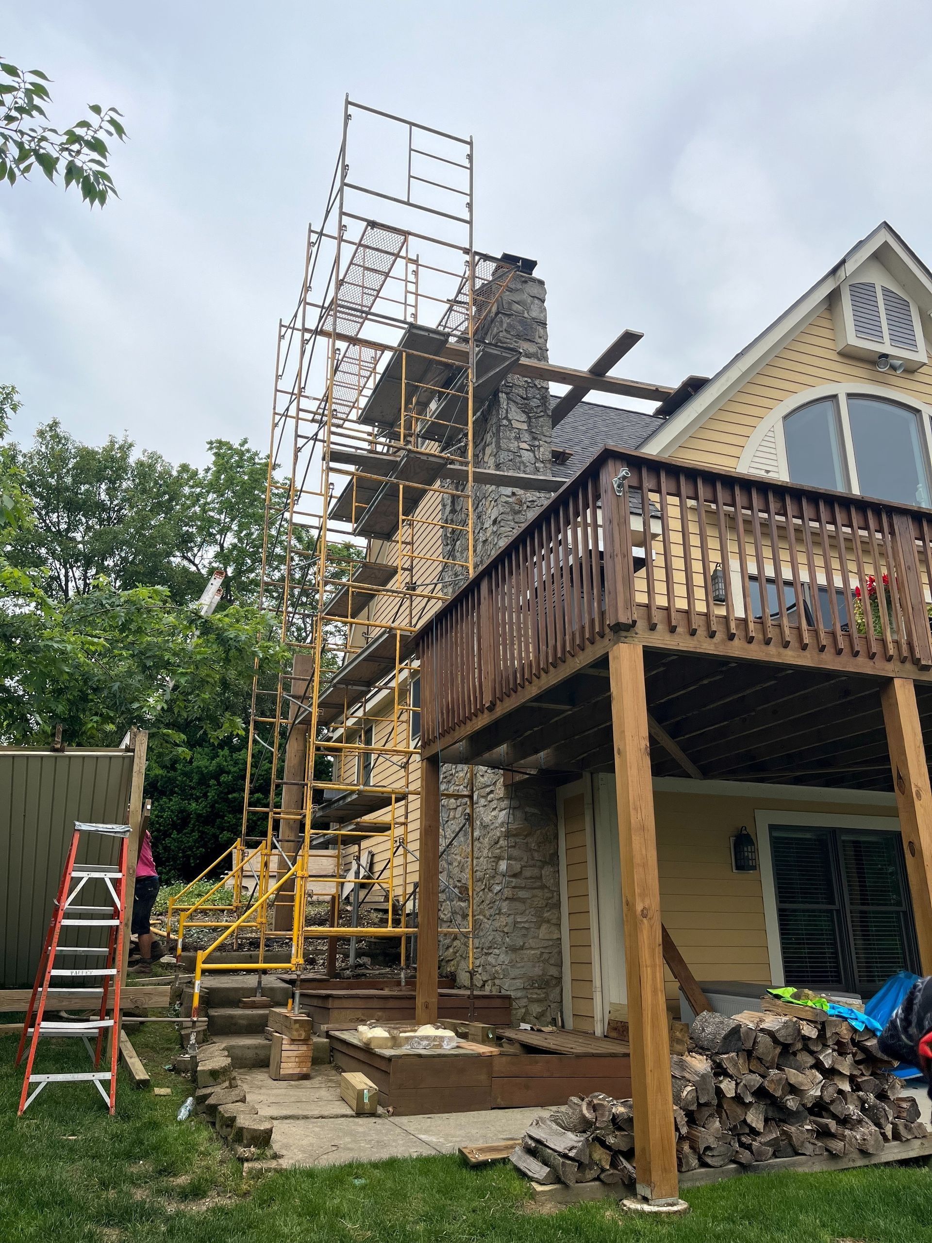 A house with a deck and scaffolding in front of it.