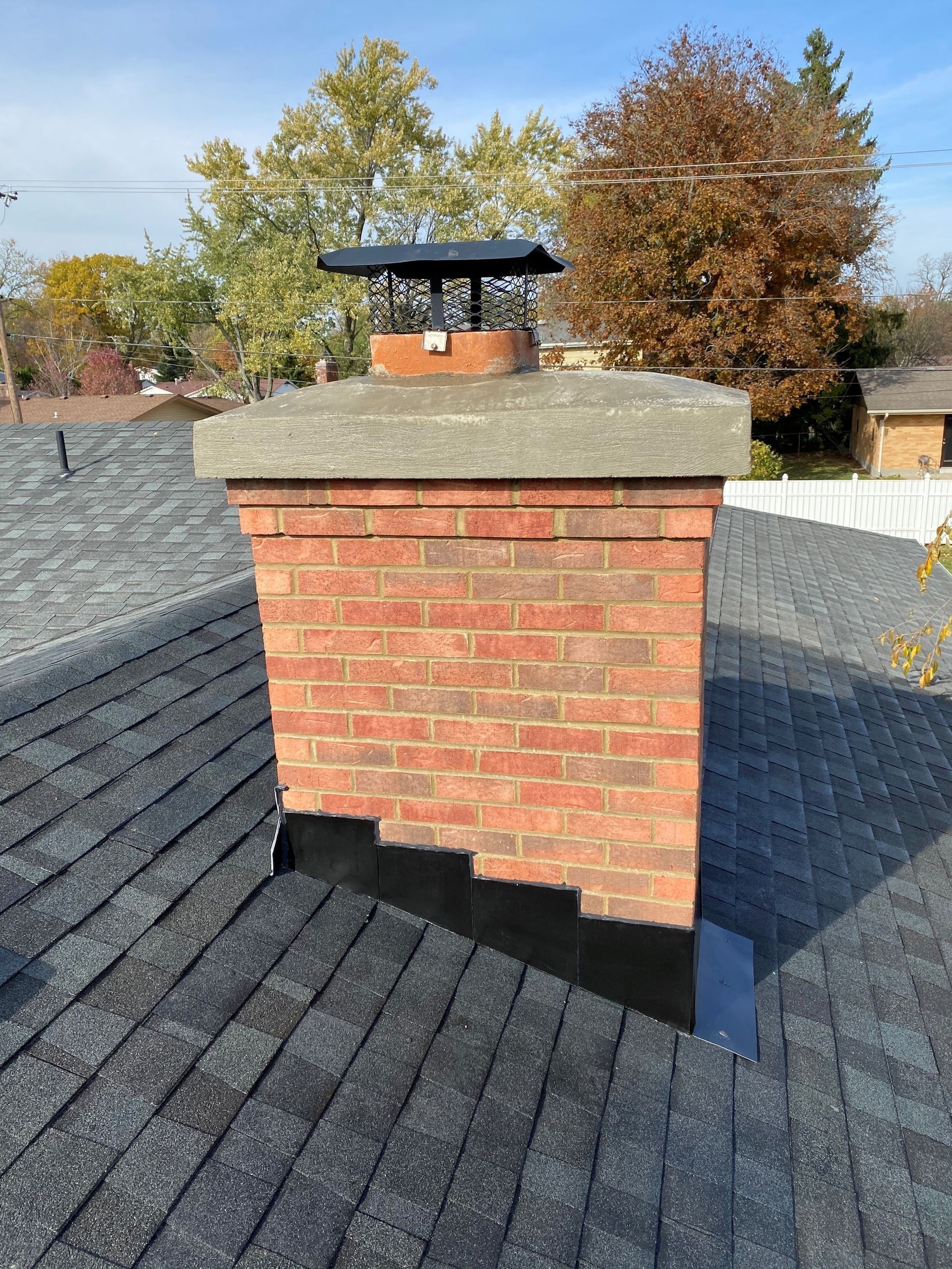 A brick chimney is sitting on top of a roof.