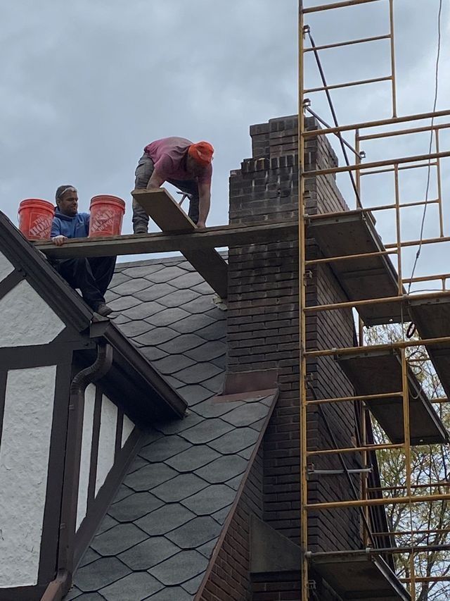 Two men are working on the roof of a house
