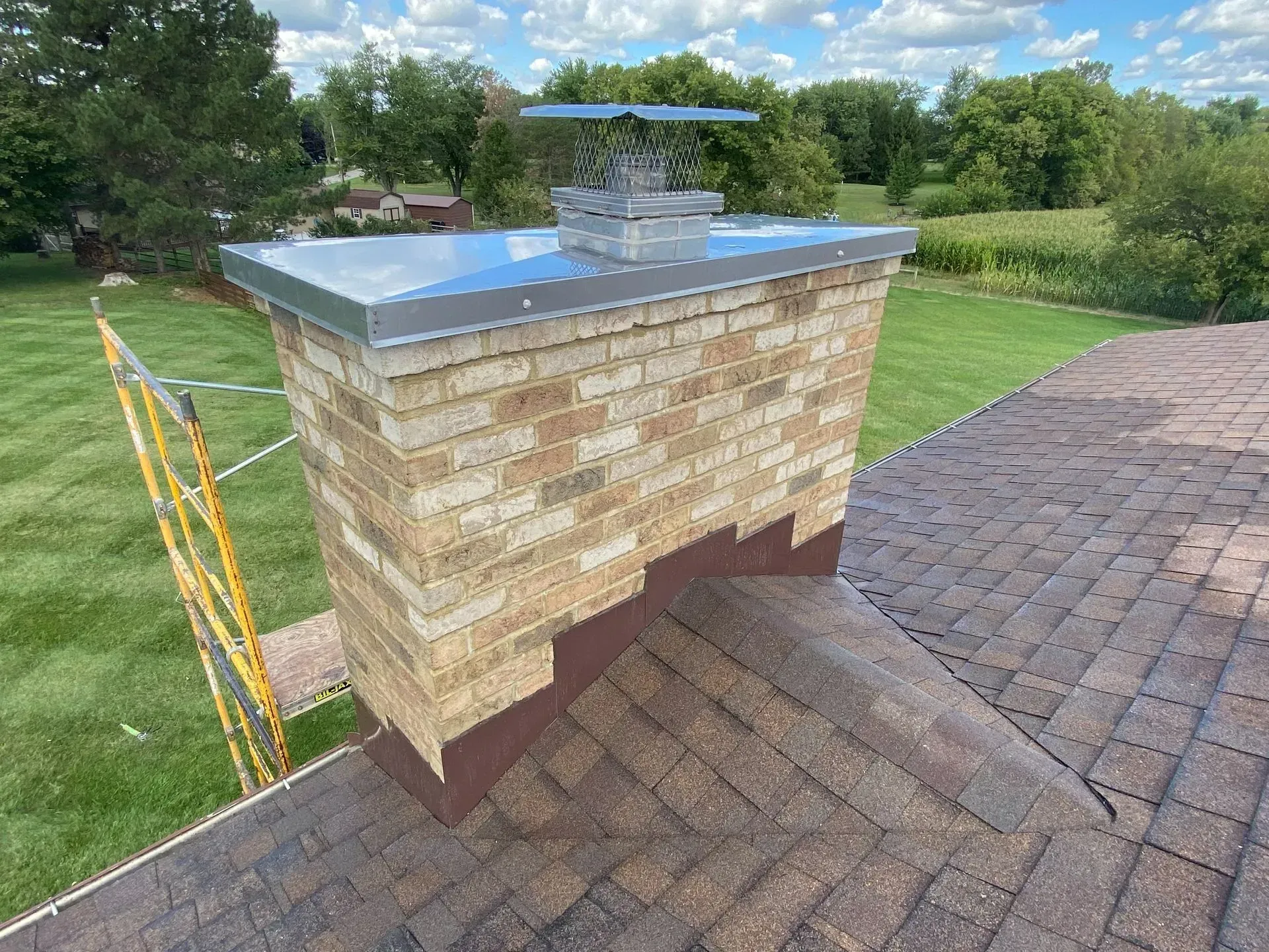 A brick chimney is sitting on top of a brick roof.