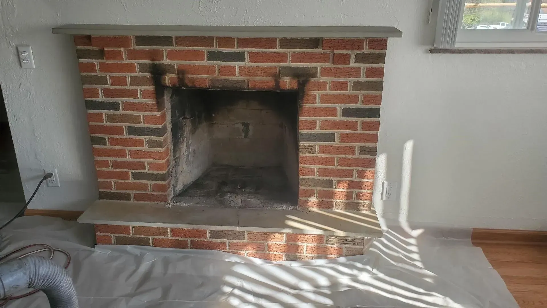 A brick fireplace in a living room with candles in it