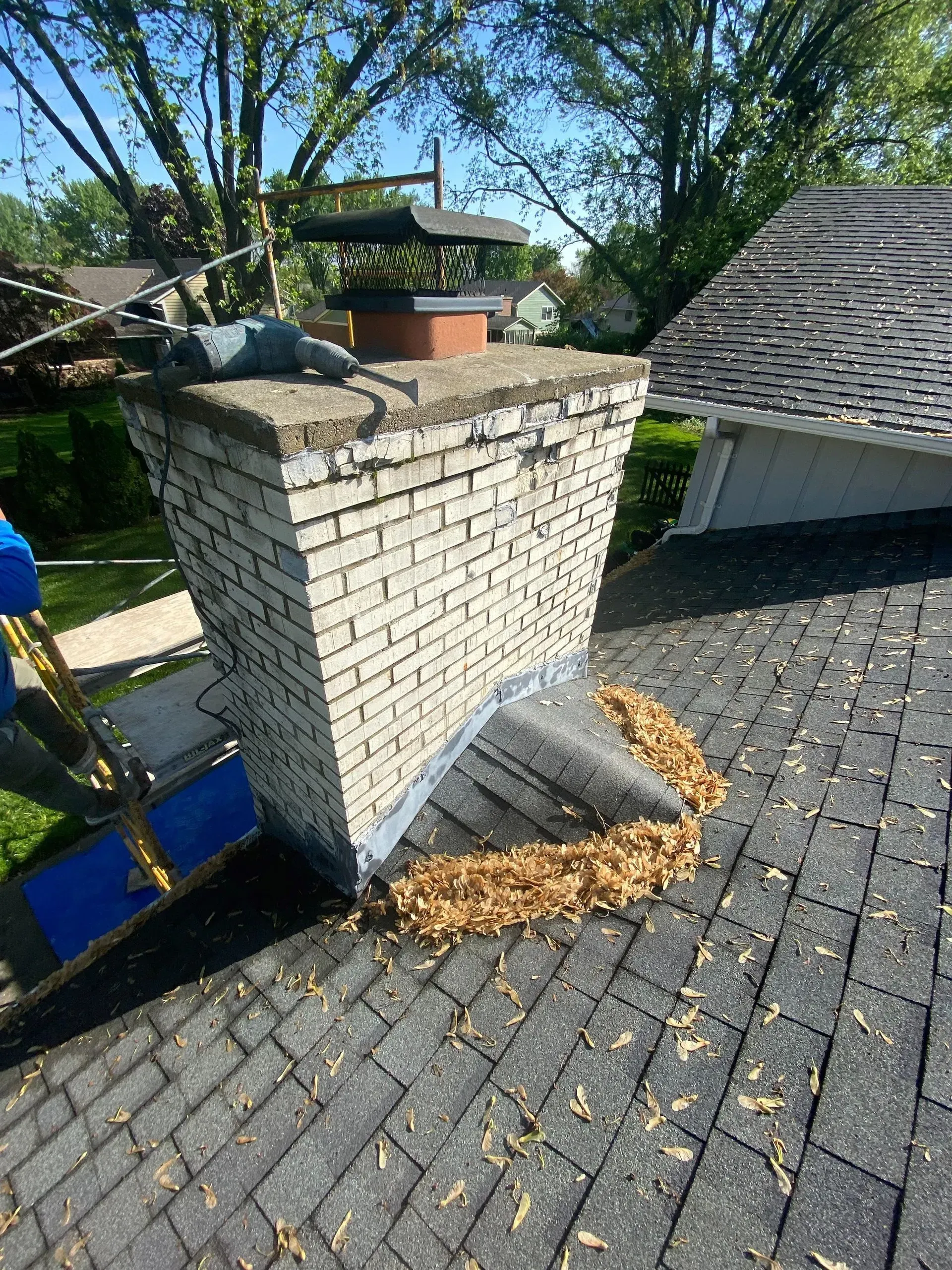 A brick chimney is sitting on top of a brick roof.
