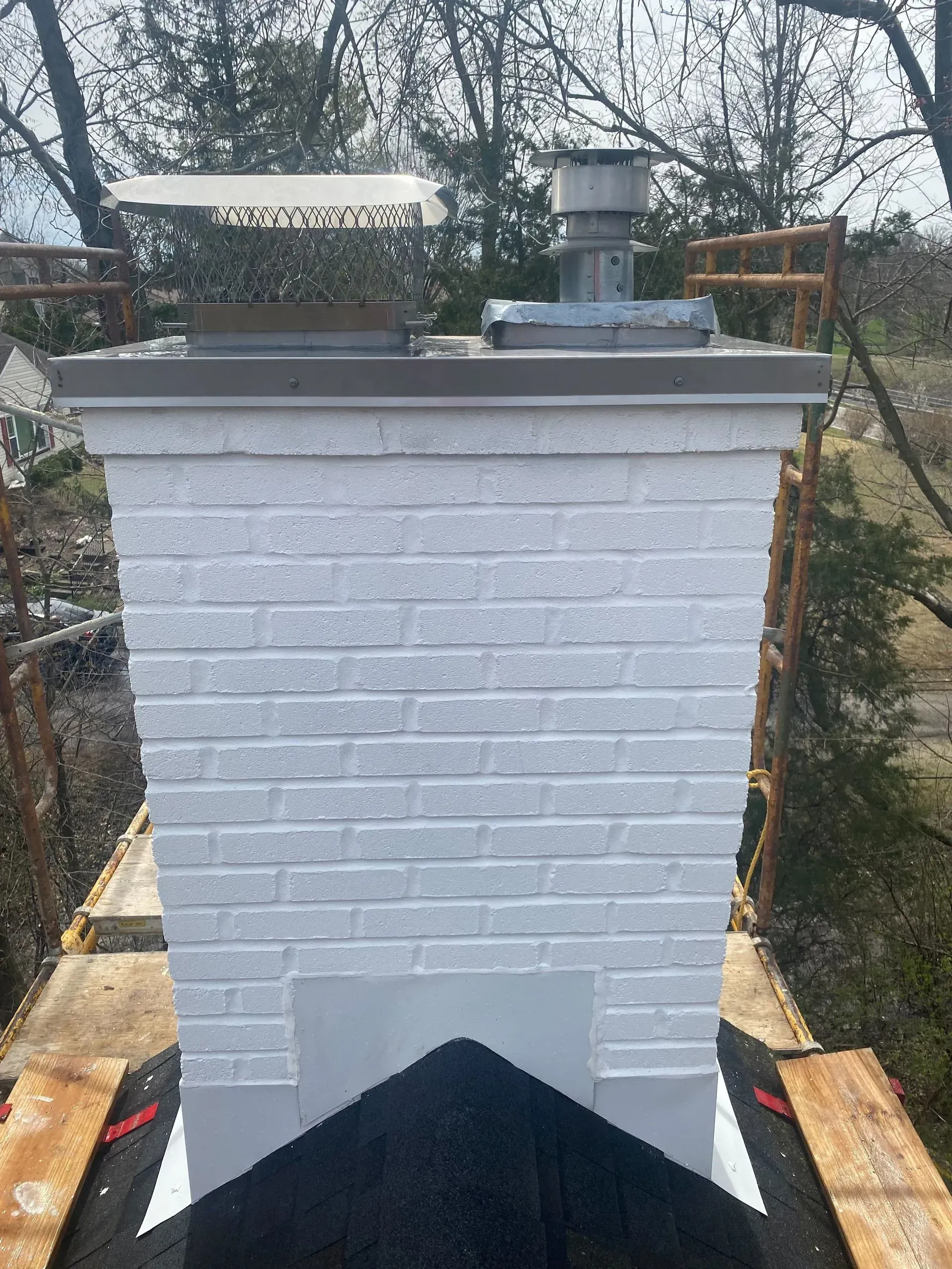 A white brick chimney is sitting on top of a wooden platform.