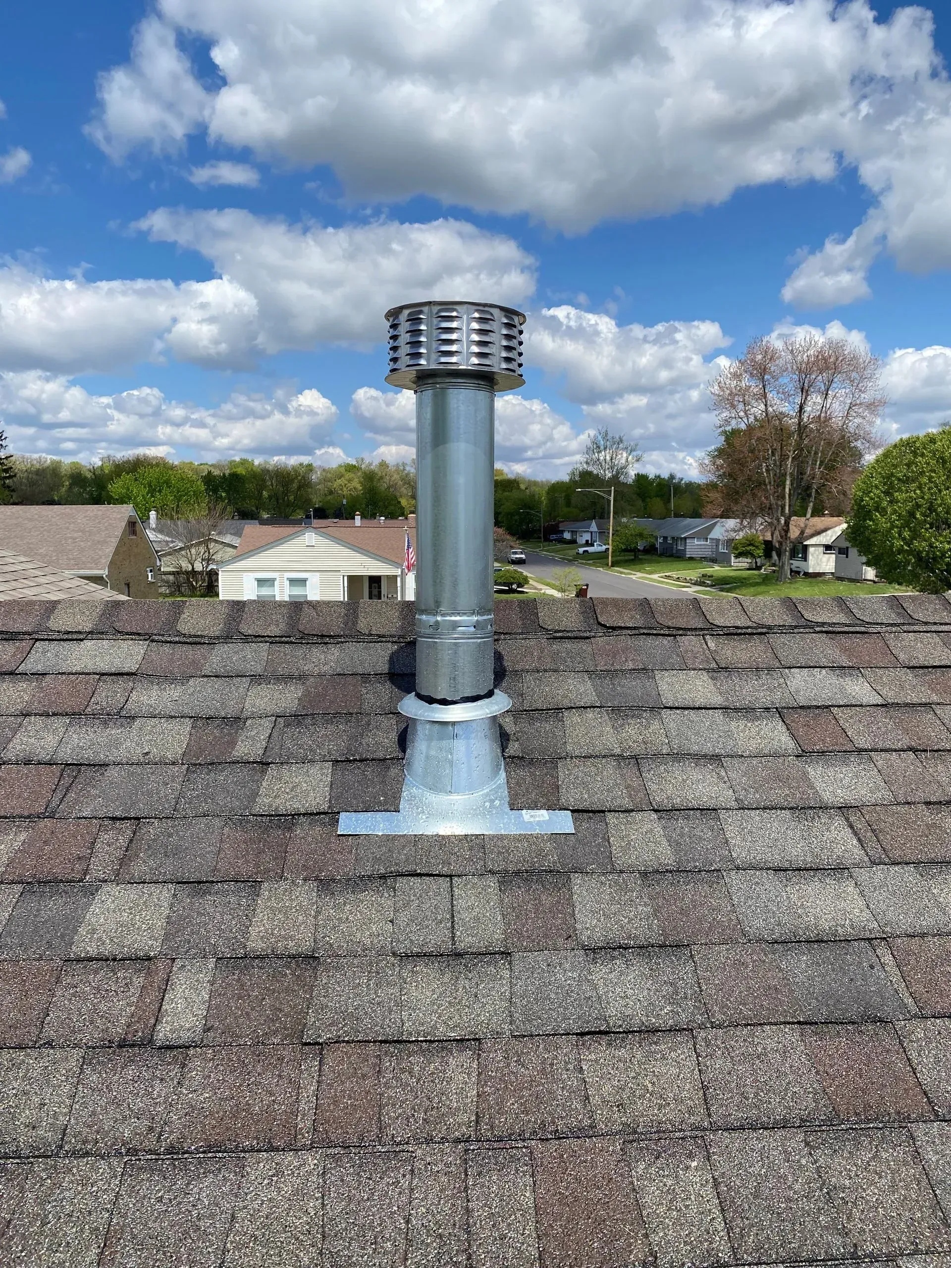 There is a chimney on the roof of a house.