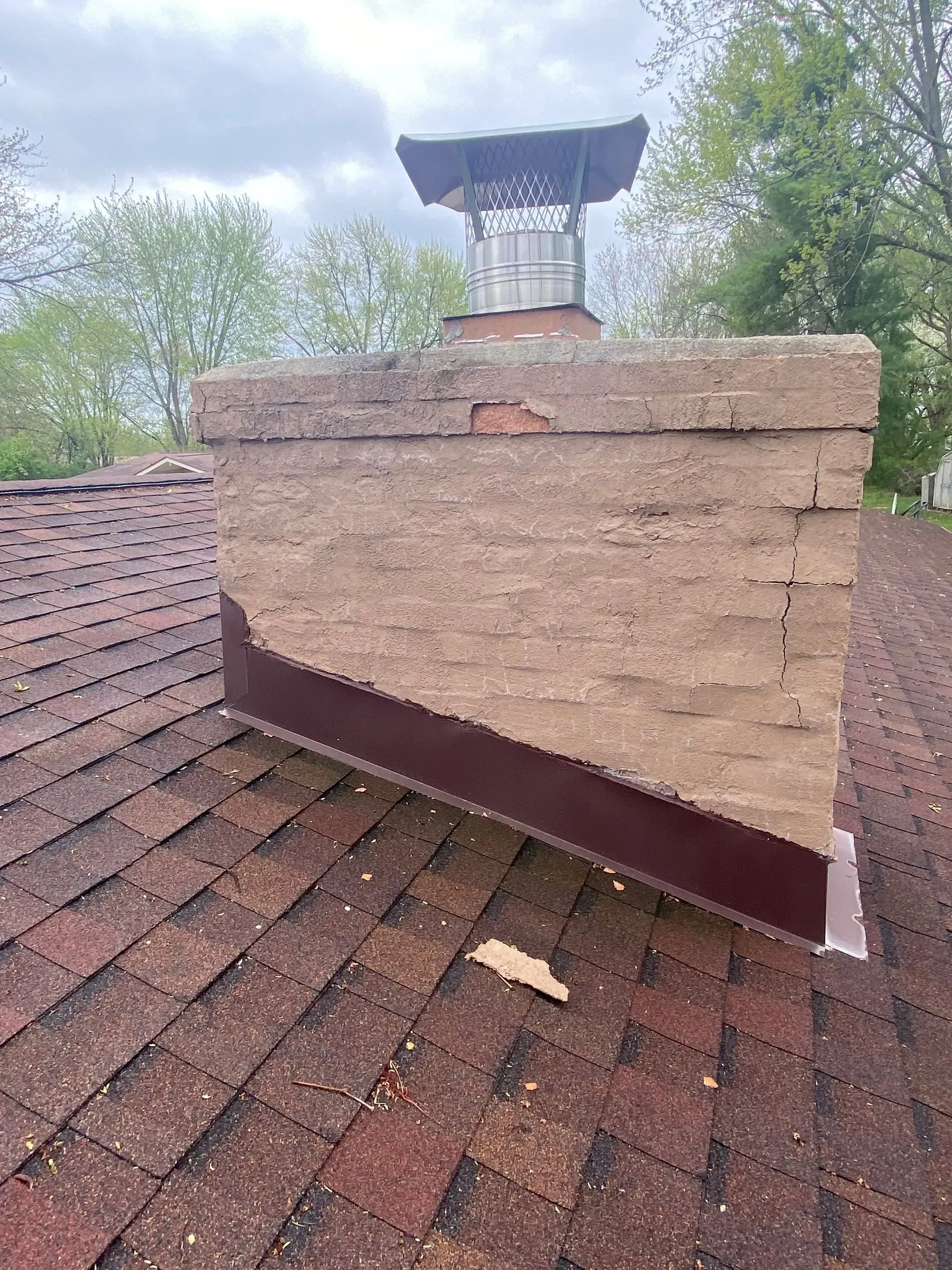 A brick chimney is sitting on top of a roof.