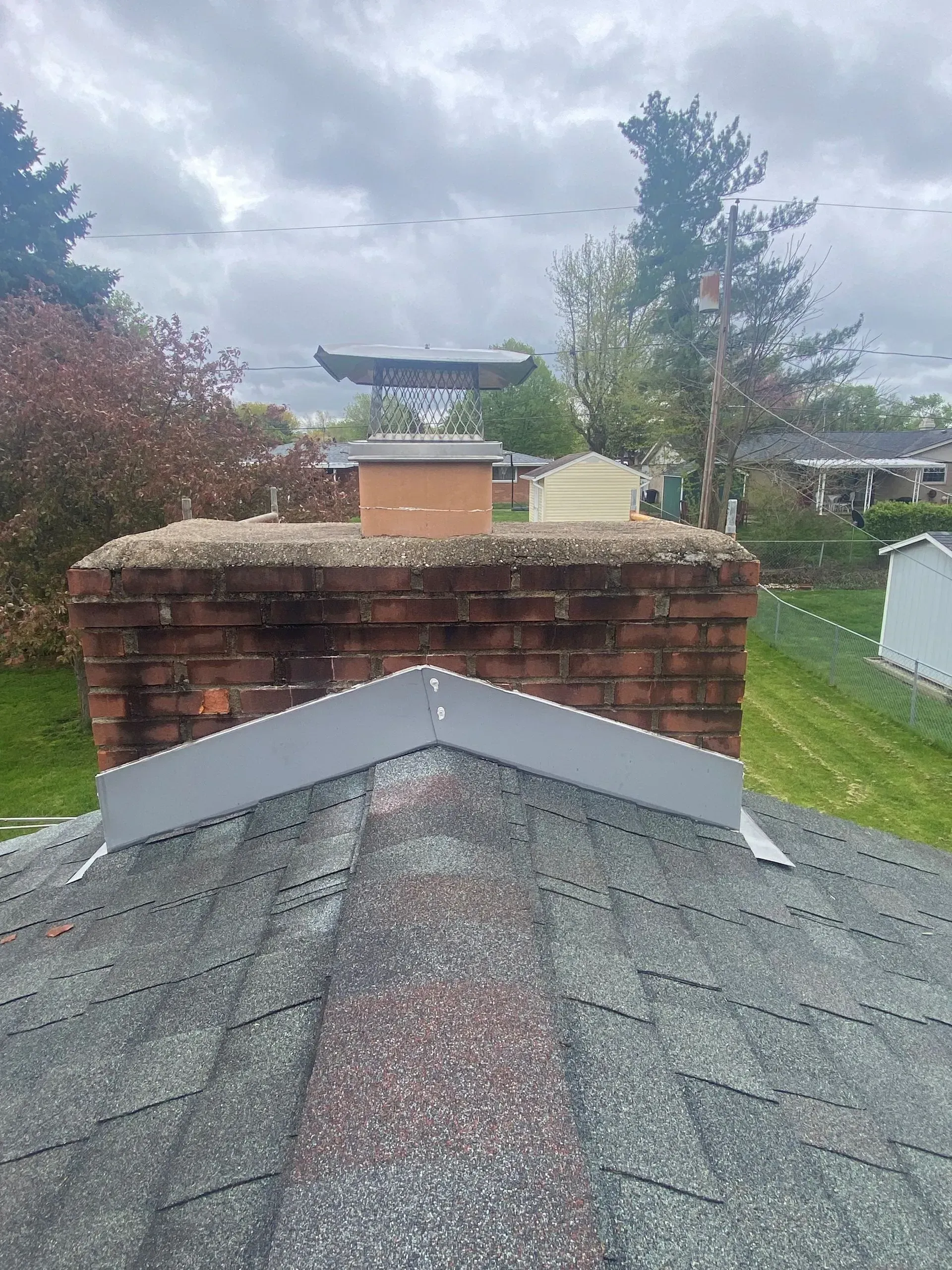 A roof with a brick chimney on top of it.