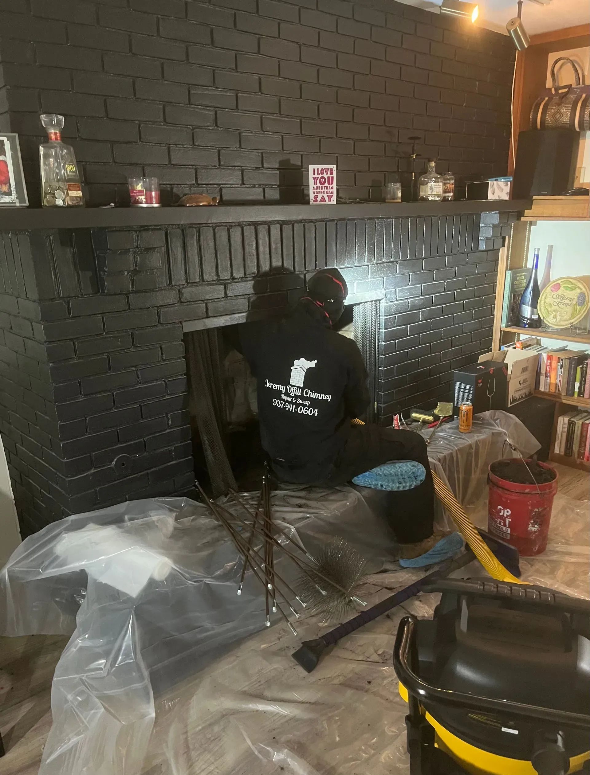 A man is sitting in front of a fireplace in a living room.