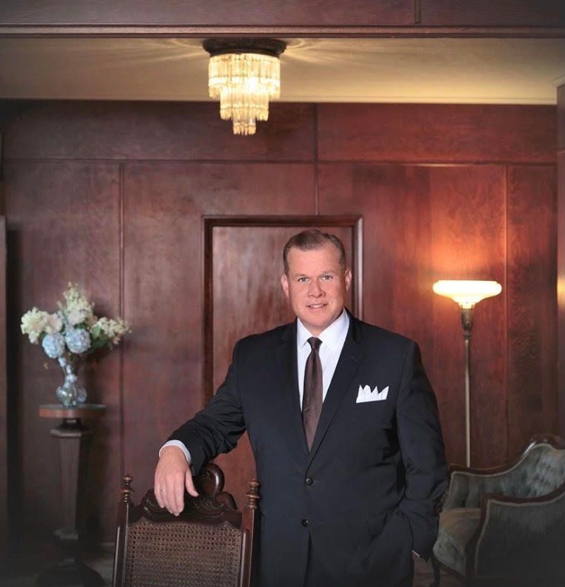 a man in a suit and tie is standing in a living room
