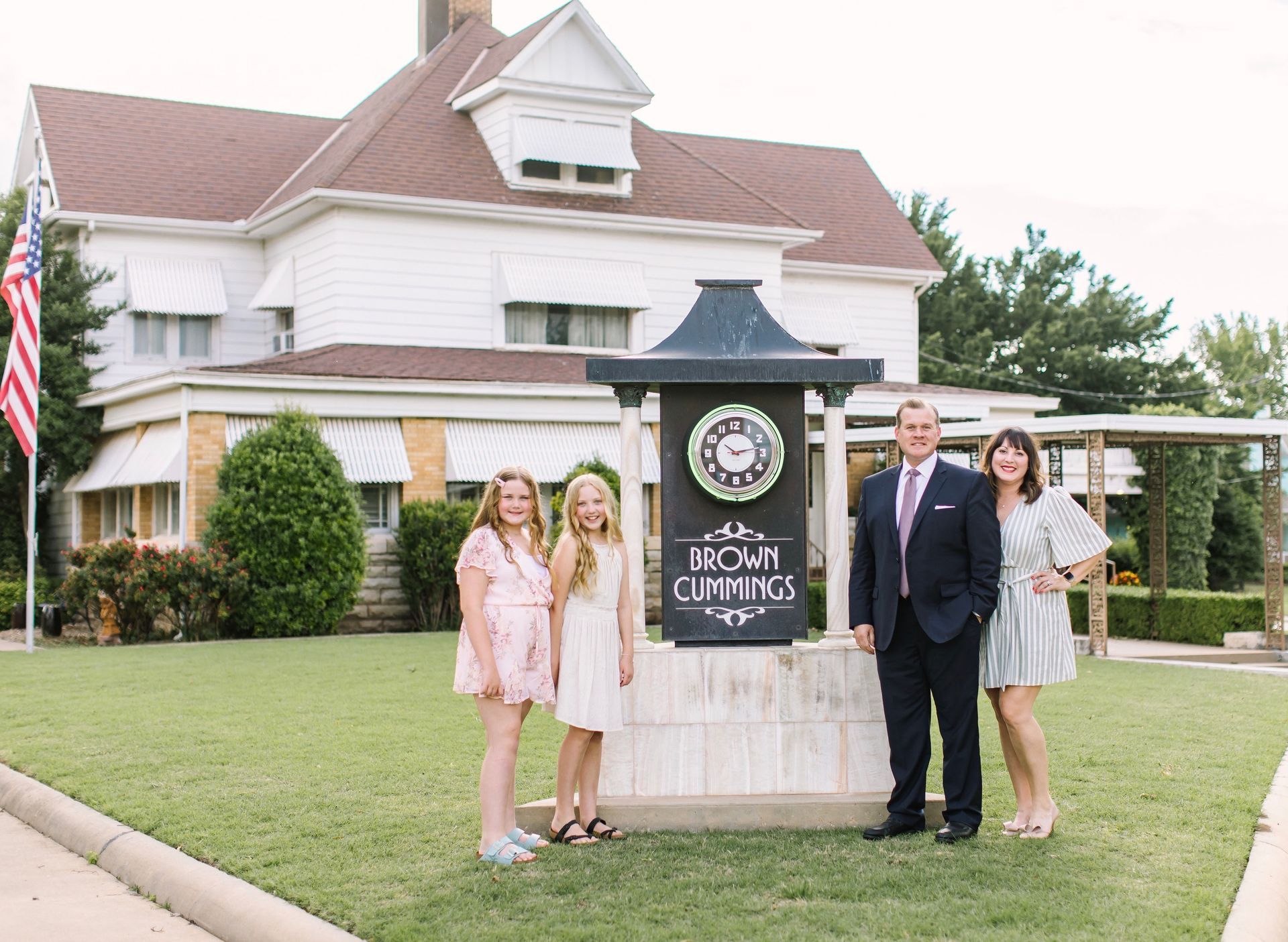 a family standing in front of a house with a sign that says brown cummings