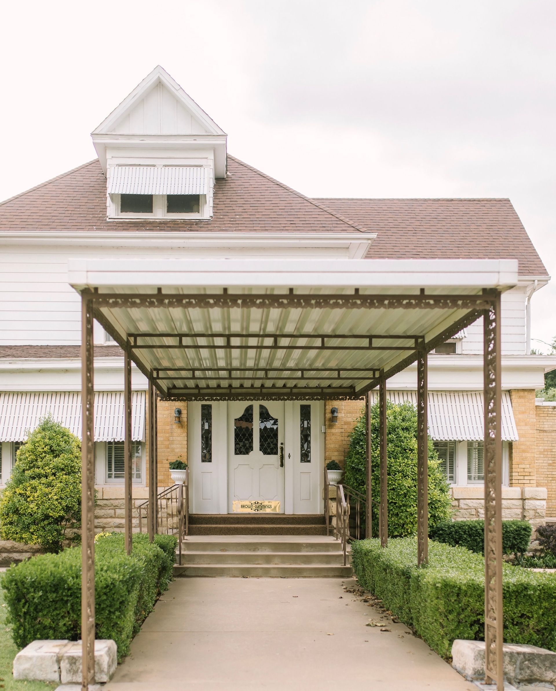 a house with a covered walkway leading to the front door