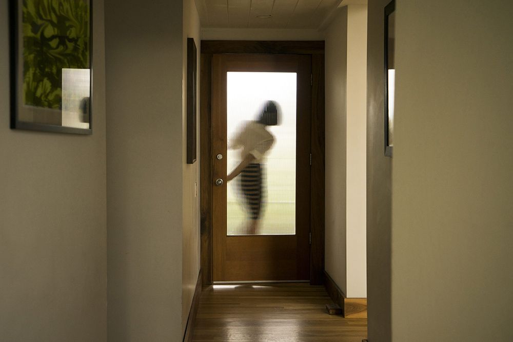 Woman Closing an Crimsafe iQ smart door — Homemakers Lifestyle Maroochydore In Maroochydore QLD