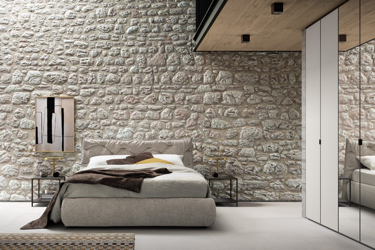 Una camera da letto con un muro di mattoni e un letto.