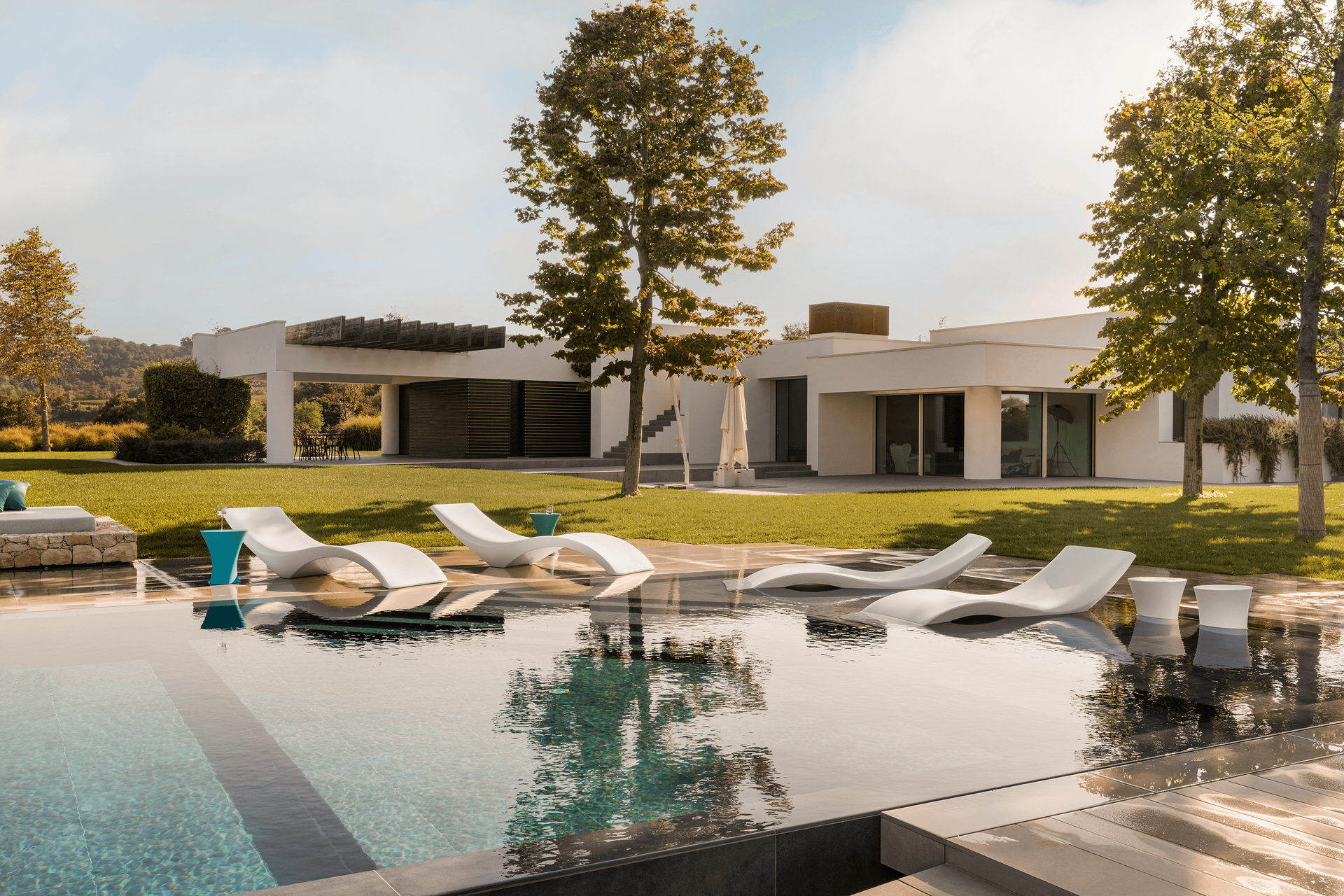 Una grande casa bianca con una piscina di fronte