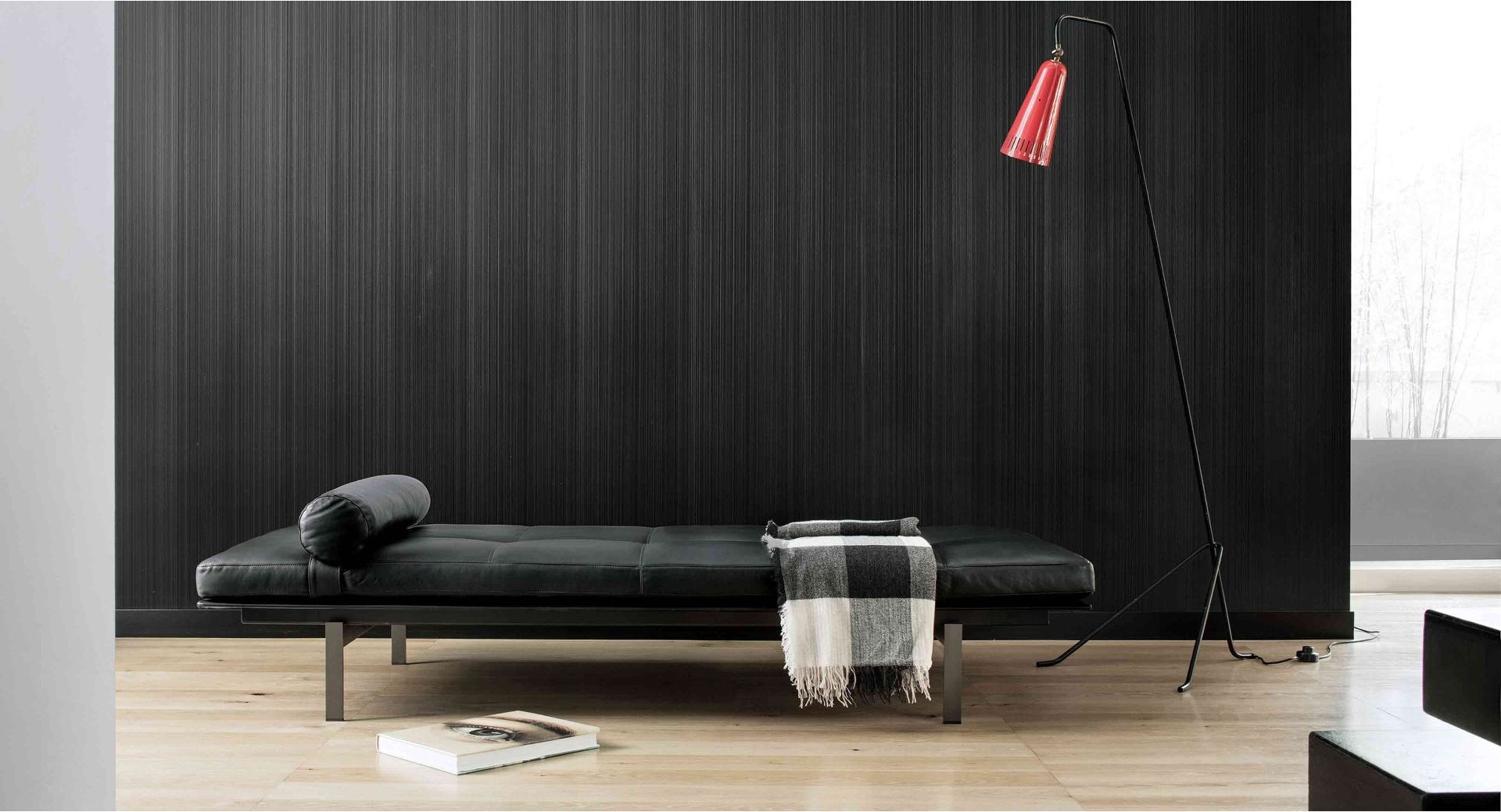 Un divano letto in pelle nera è posizionato nel soggiorno accanto a una lampada.