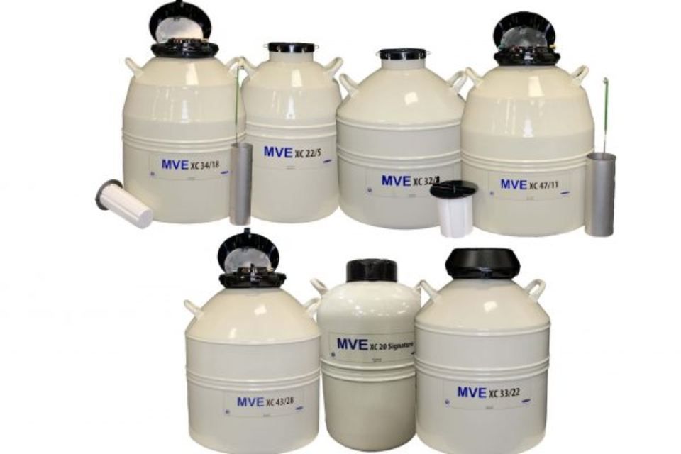 Assorted white industrial filter tanks and canisters with black lids arranged on a white background