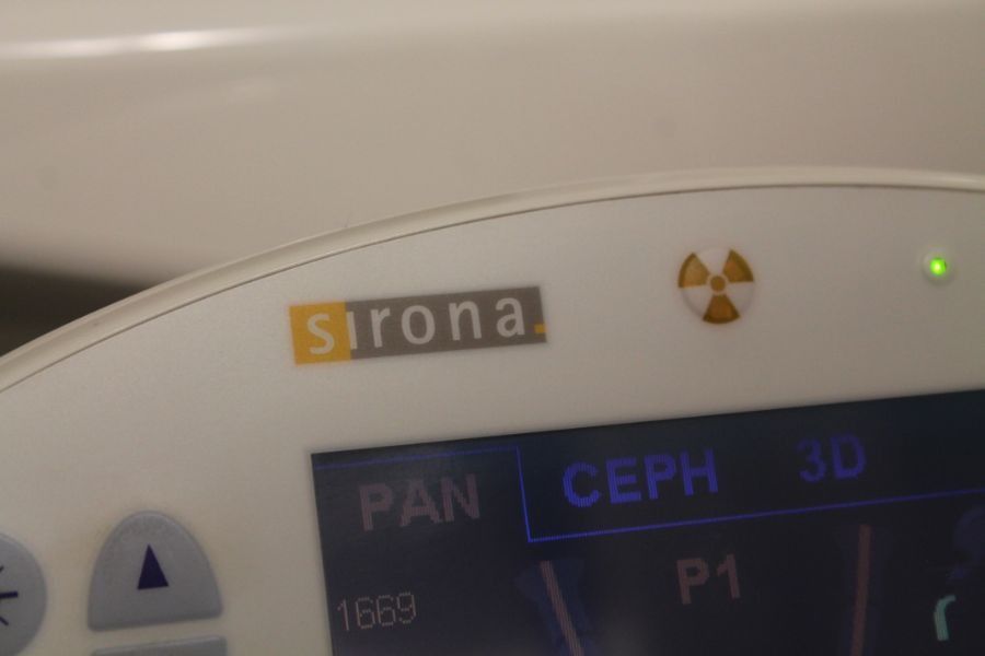Primo piano del display di un apparecchio odontoiatrico Sirona con le opzioni PAN e CEPH illuminate di verde.