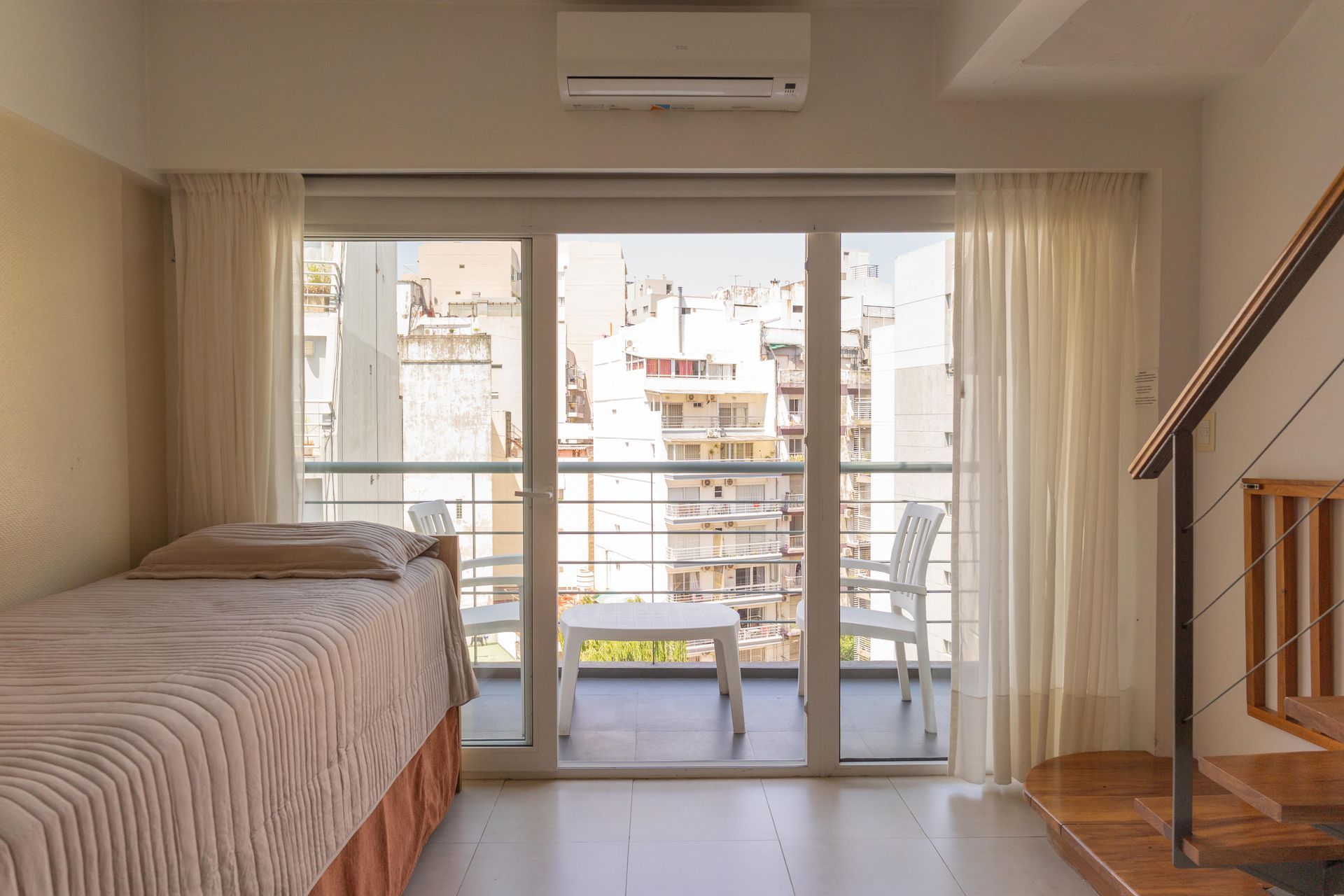 Una sala de estar con una escalera y una mesa y sillas.