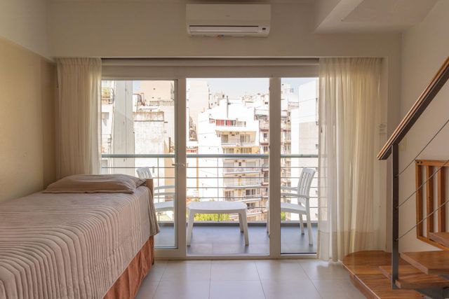Una sala de estar con una escalera y una mesa y sillas.