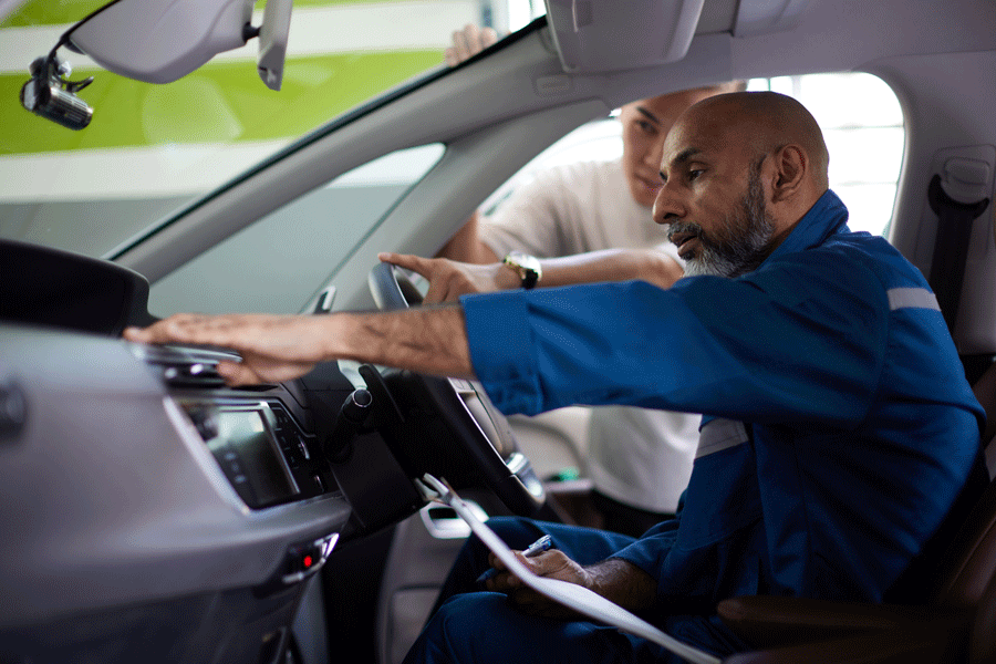 A Man in A Blue Uniform Is Sitting in A Car with Another Man.