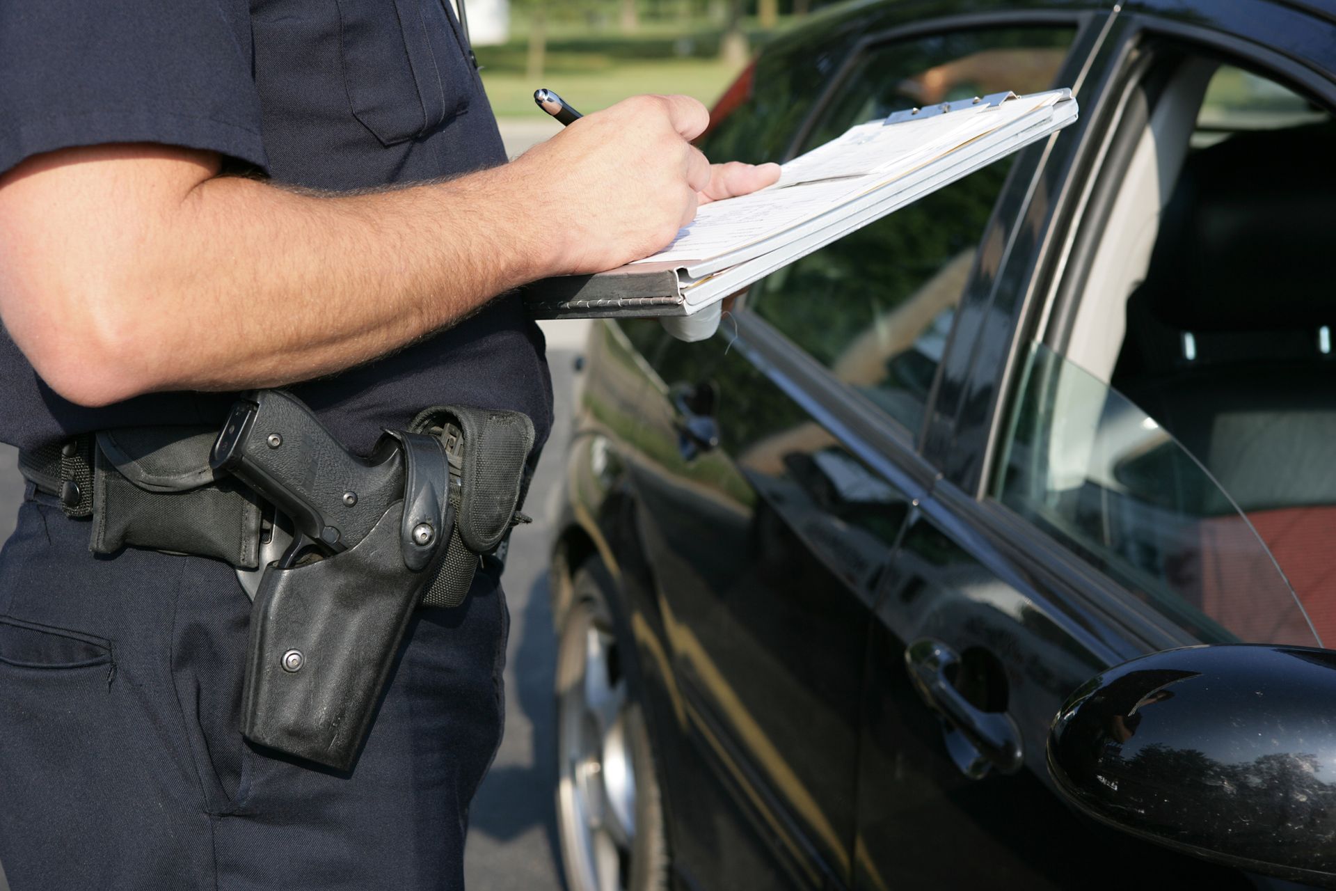 Policeman writing a ticket to a driver who can benefit from Bates Law Firm PLLC traffic ticket defense in Anson County, NC.