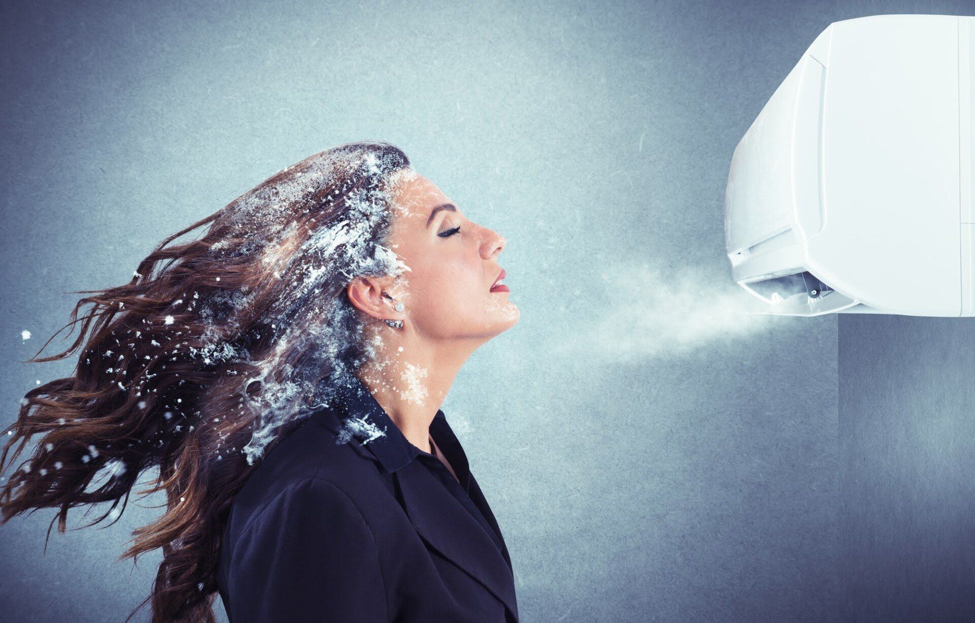 Woman with snowy hair, standing in front of an AC unit with cool air blowing out.
