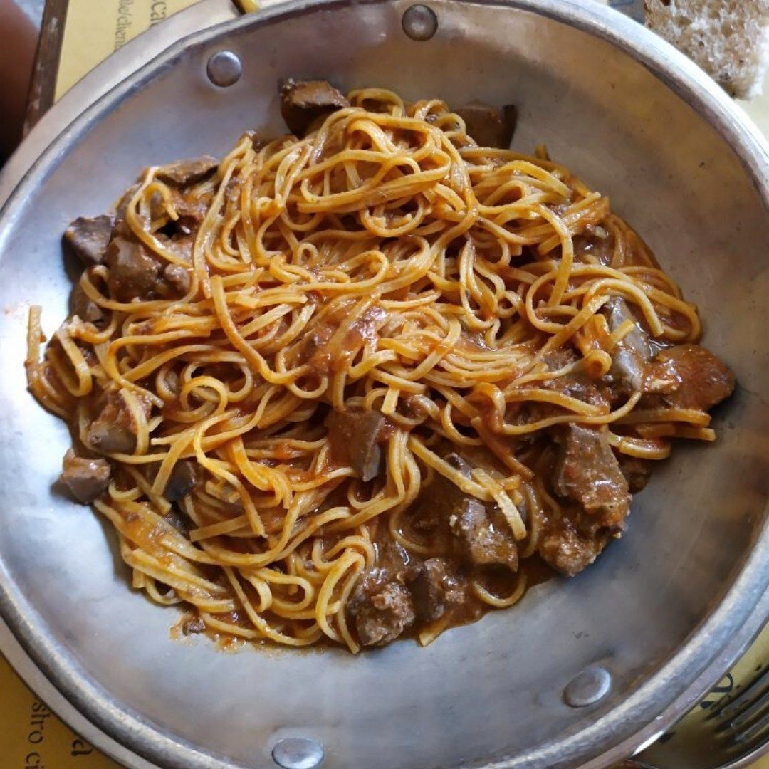 Una ciotola di spaghetti con carne e salsa su un tavolo