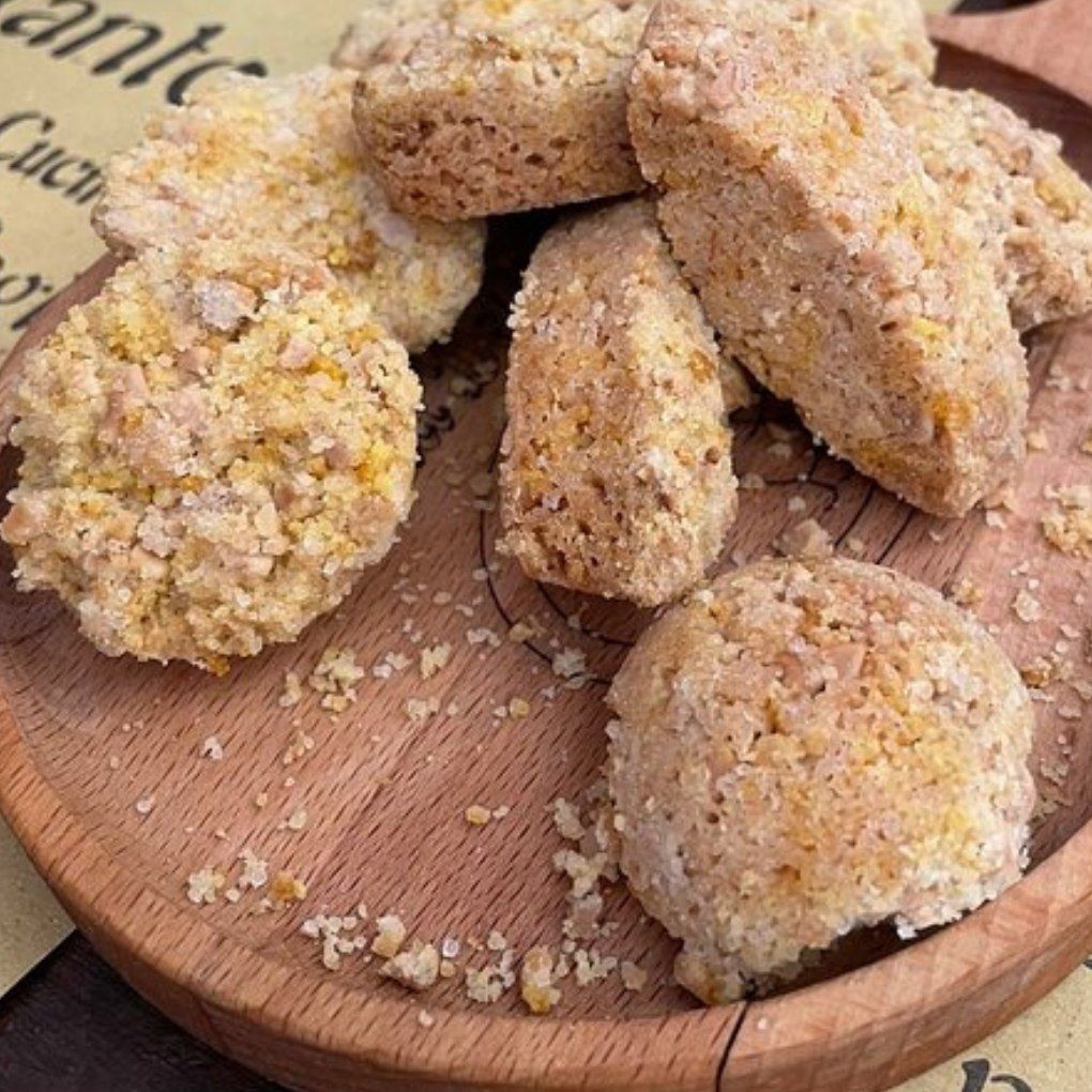 A wooden plate topped with a pile of biscuits and crumbs