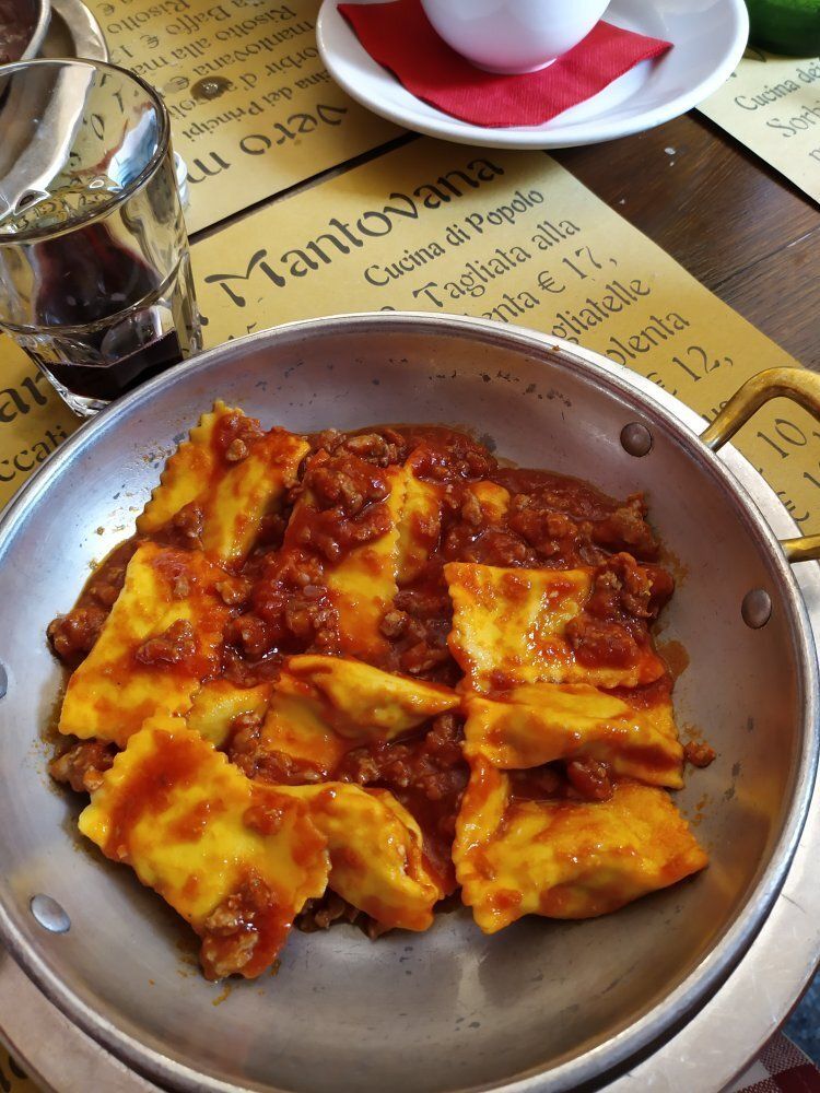 A pan of ravioli with tomato sauce on a table
