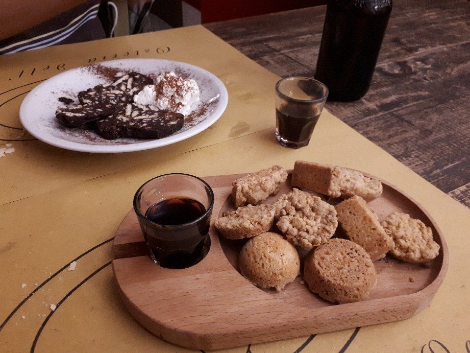 A plate of food and a small glass of coffee on a table