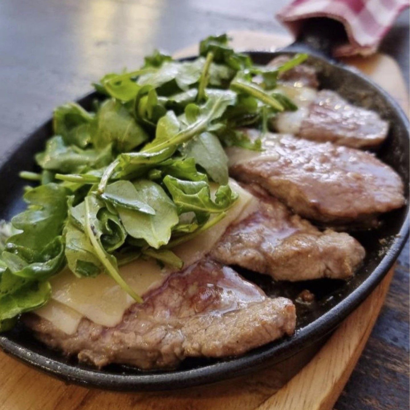A pan full of meat and vegetables on a wooden table