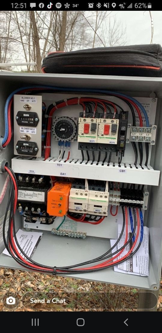 A person 's hand is reaching into an electrical box.