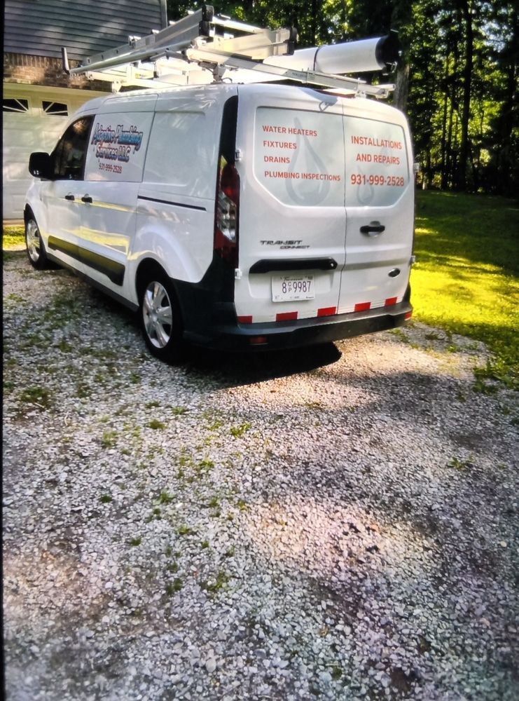 White service van parked on gravel beside a grassy yard, with ladder racks on top and company markings on the side