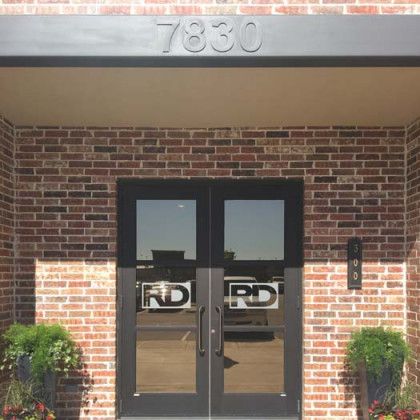 Brick building entrance with black double doors, 